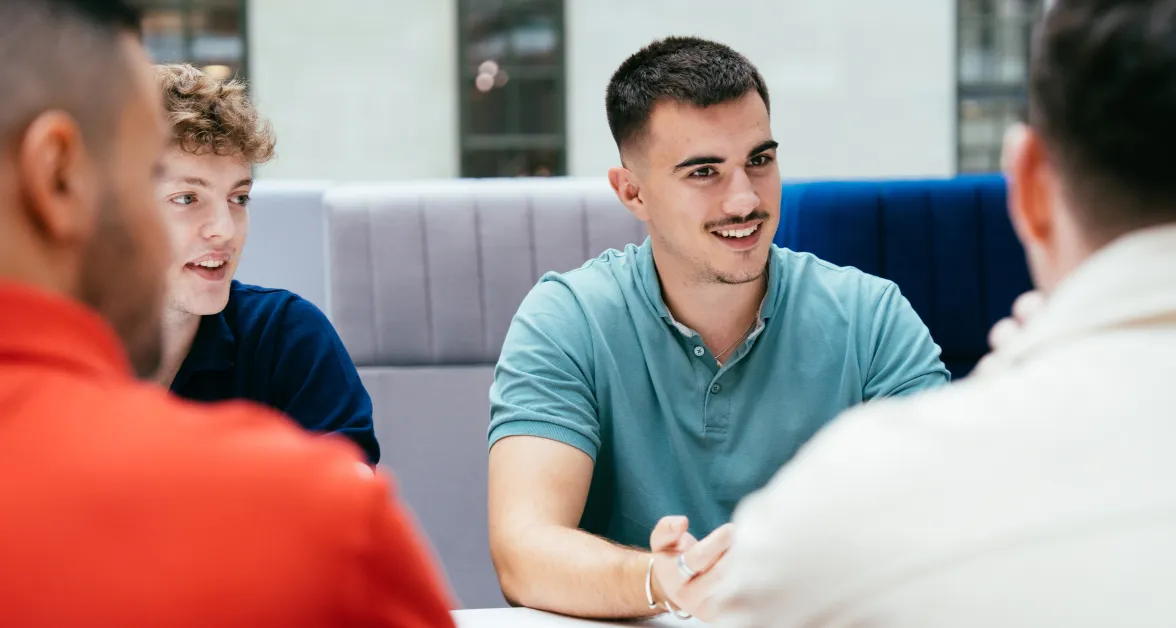 Group of young men chatting and smiling, capturing the collaborative and vibrant environment at Aviva where future careers are shaped.